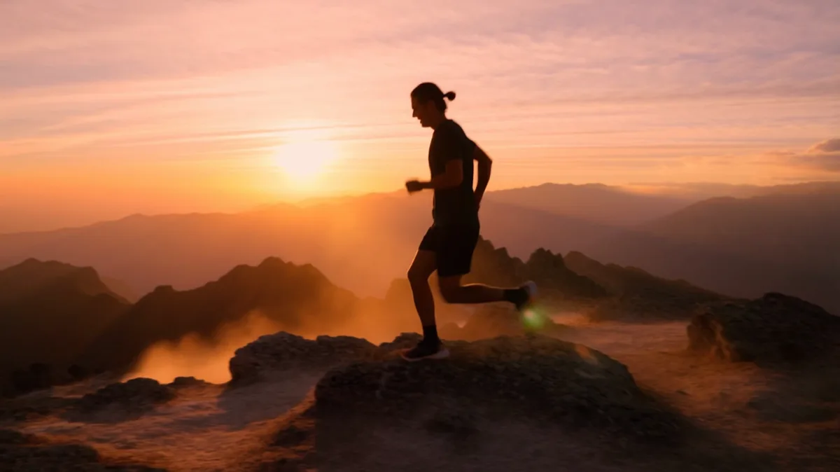 Runner on a ridge trail at sunset
